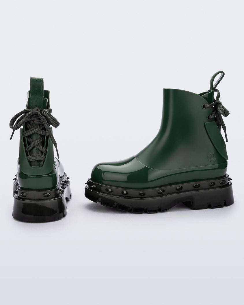 An angled side and back view of a pair of green Melissa Spikes Boots with spike details around the sole and laces in the back.