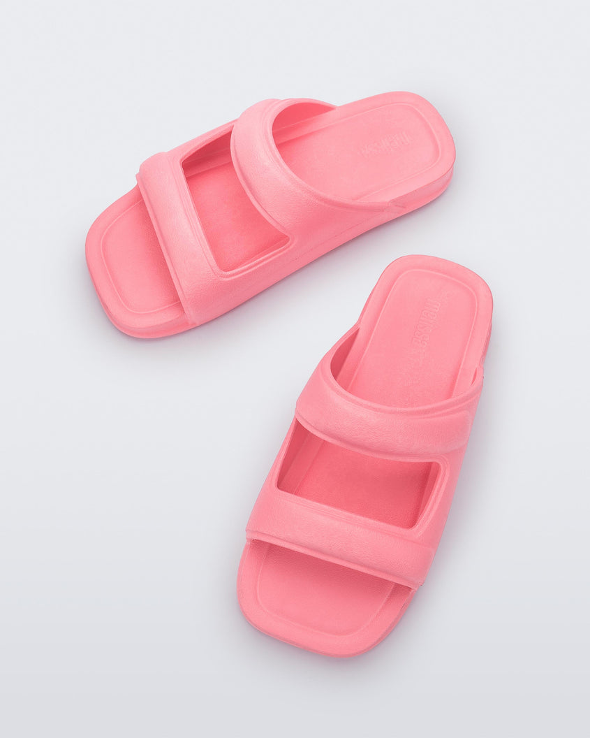 Top view of a pair of pink Melissa Free Grow slides with a square cut out on the front.