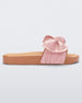 Side view of a beige/pink Melissa Tie Beach slide with a beige base and a pink bow on the top strap.