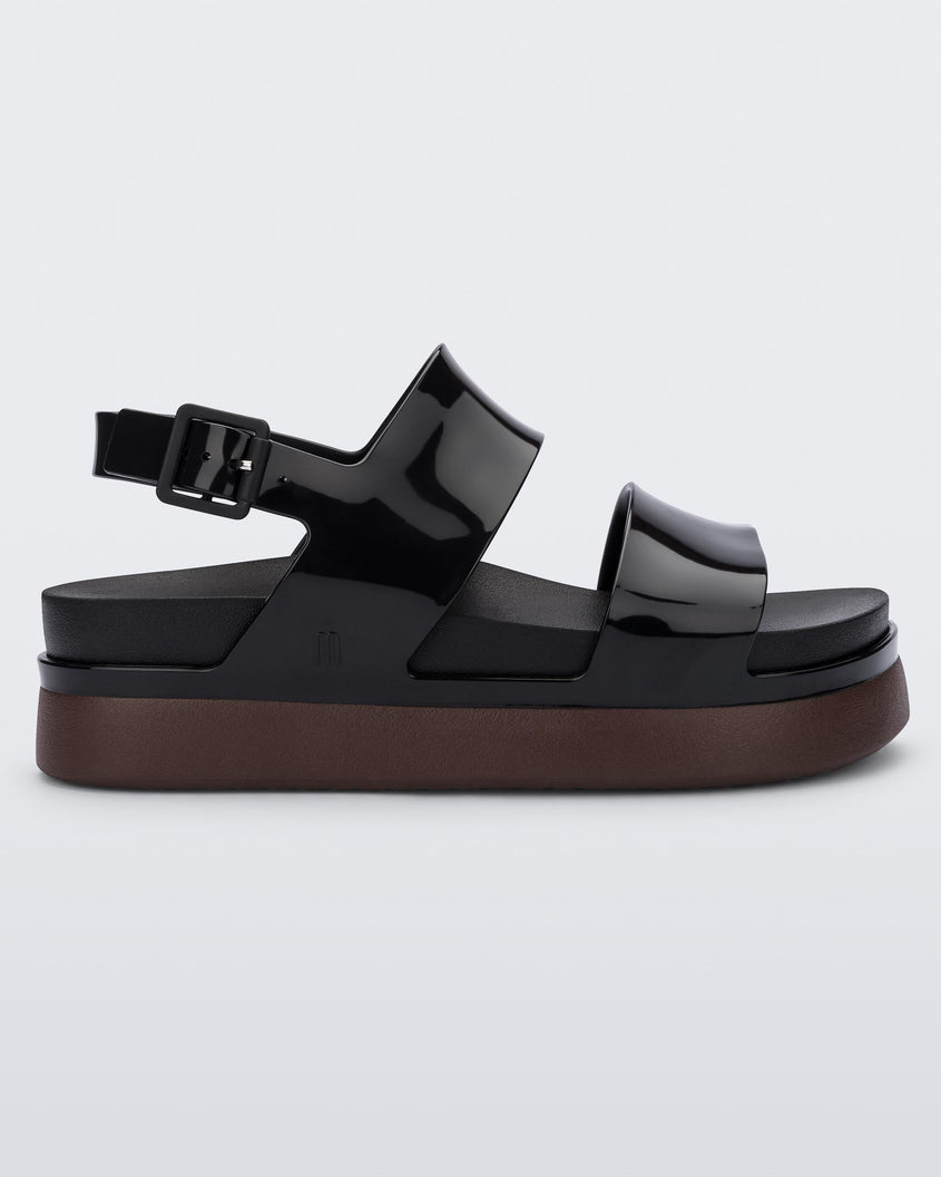 Side view of a black/brown Melissa Cosmic platform sandals with a brown sole and two black straps.