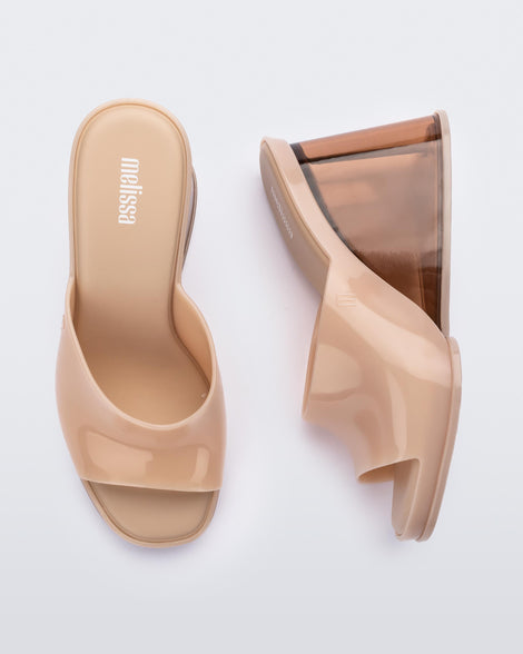 A top and side view of a pair of beige Melissa Darling heels with clear soles.