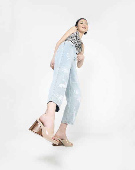 A model posing for a picture wearing a pair of beige Melissa's Darling heels with clear soles.