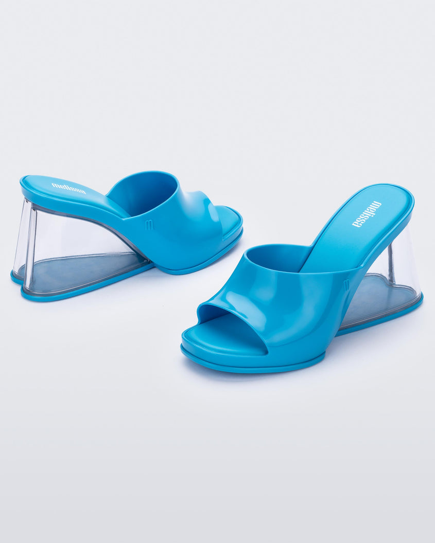 Side view of a pair of blue Melissa Darling heels with clear soles.