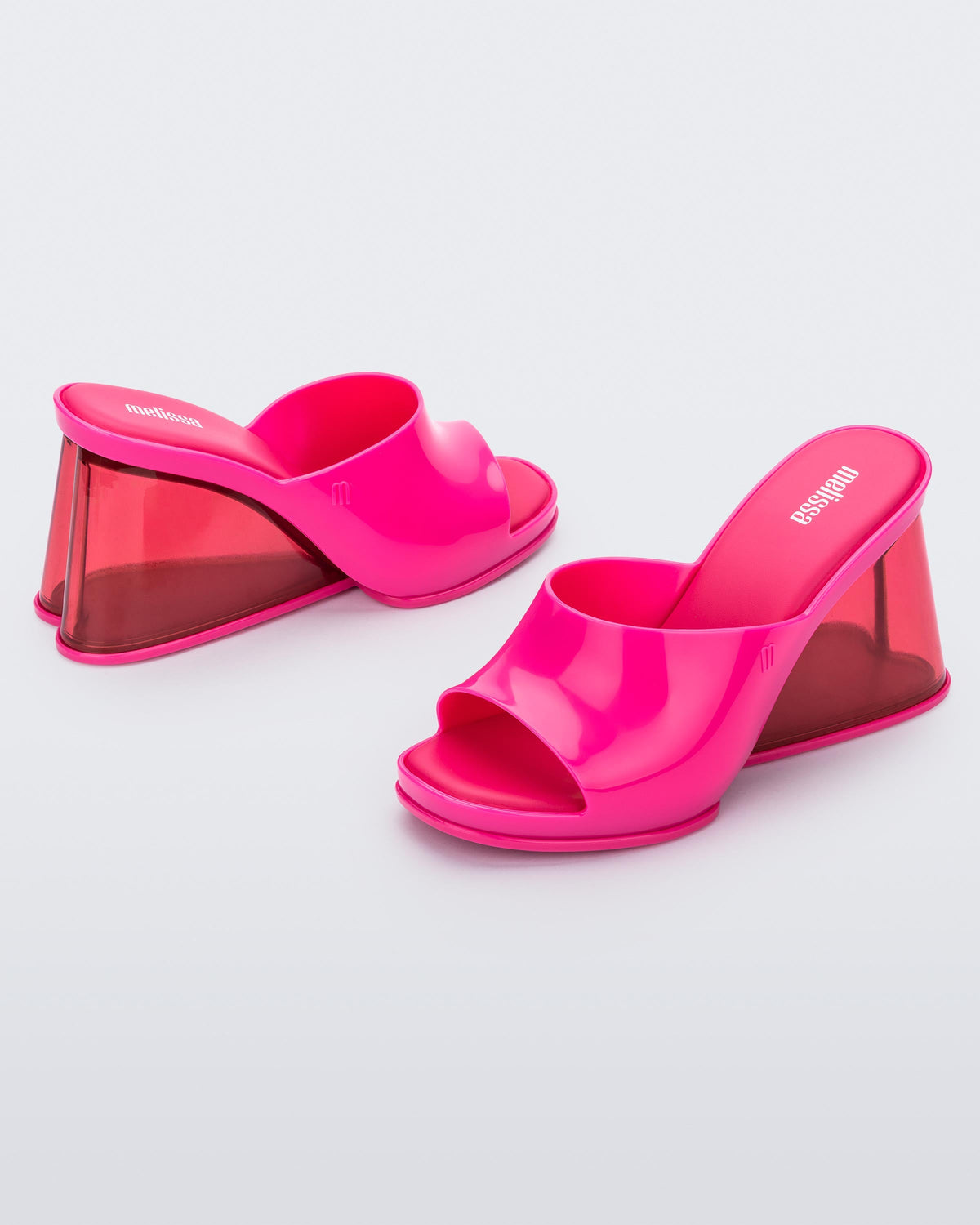 Side view of a pair of pink Melissa Darling heels with clear soles.