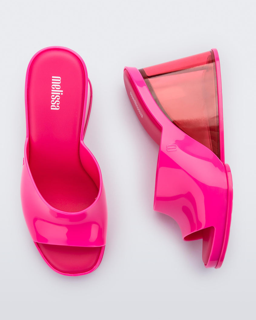 A top and side view of a pair of pink Melissa Darling heels with clear soles.
