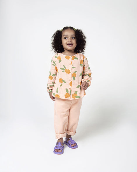 A model posing for a picture wearing a pair of lilac Mini Melissa Freesherman sandals with lilac and clear glitter straps.