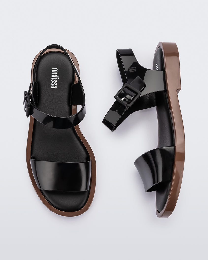 A top and side view of a pair of brown/black Melissa Mar Sandal with two black straps and a brown sole.