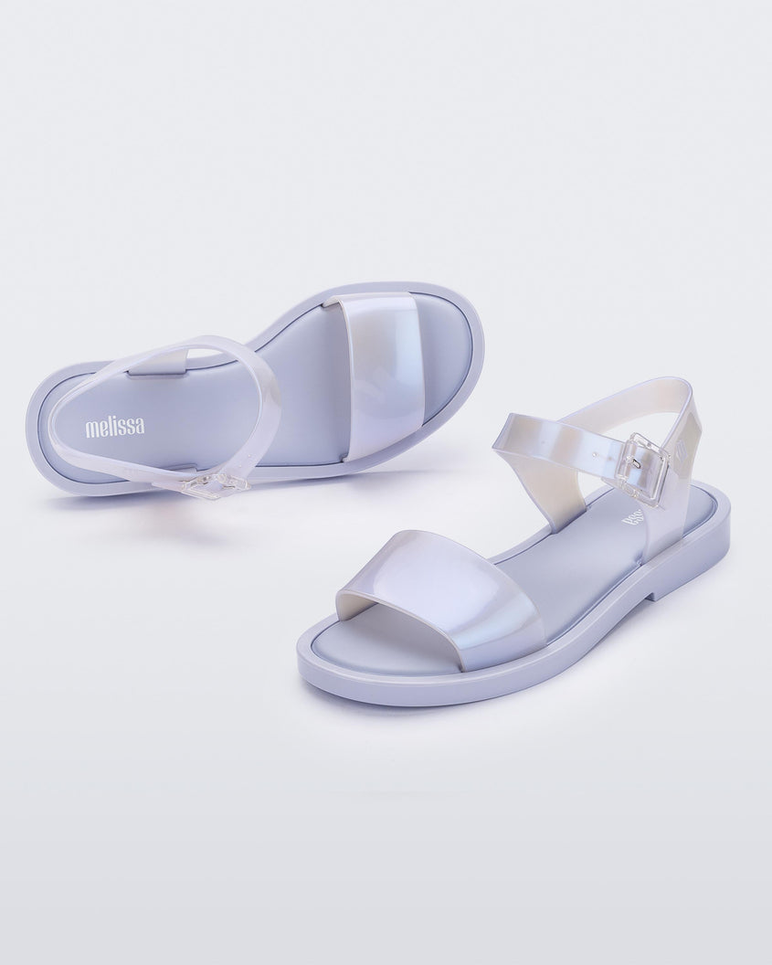 An angled front and side view of a pair of lilack/blue pearl Melissa Mar sandals with two straps.