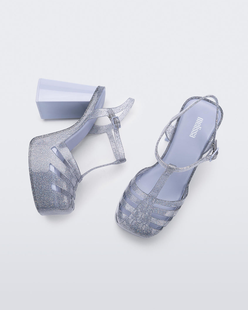 A top and side view of a glitter clear Melissa Party Heel with several straps and a closed toe front.