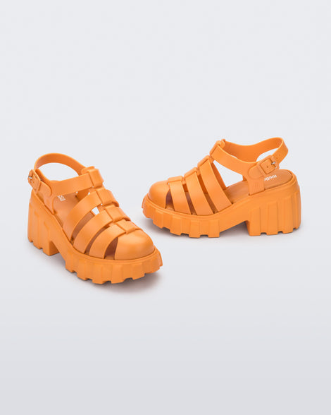 Angled view of a pair of orange Melissa Megan platform heel sandals.