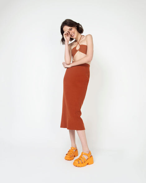 A woman in a brown dress wearing a pair of orange Melissa Megan planform heel sandals.