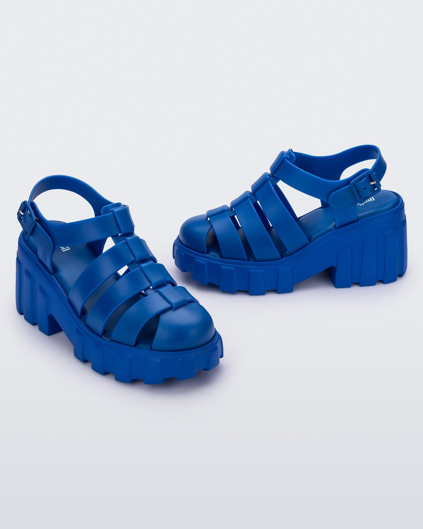 Angled view of a pair of blue Melissa Megan platform heel sandals.