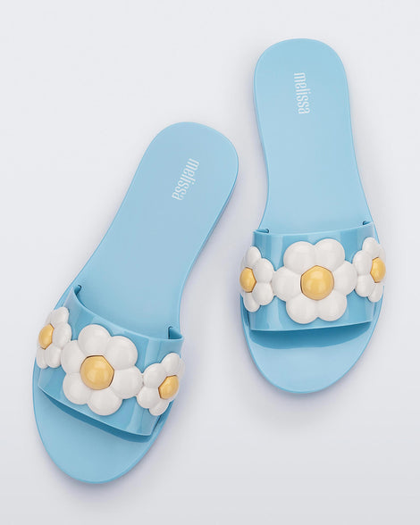 Top view of a pair of blue Melissa Babe Spring sandals with white flowers.
