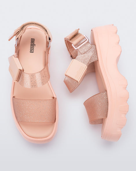 A top and side view of a pair of beige/glitter beige platform Melissa Kick Off Sandals with two glitter straps.