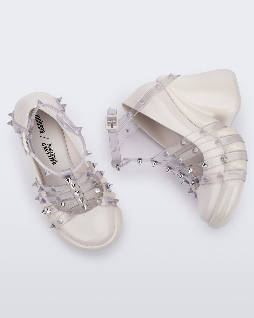 A top and side view of a pair of White/Clear Melissa Punk Love Heels with a white base and clear straps fastening at a top ankle strap with spike details.