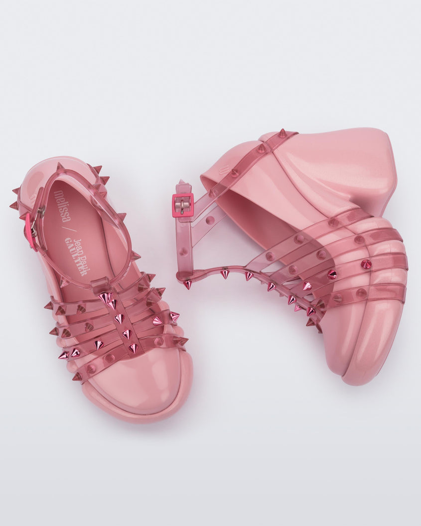 A top and side view of a pair of pink/transparent Melissa Punk Love Heels with pink straps fastening at a top ankle strap with spike details.