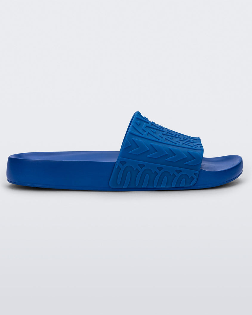 Side view of a blue Melissa Slide with the marc jacob's logo across the front strap.