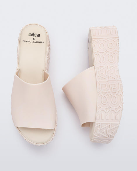 A top and side view of a pair of beige Melissa Becky platform slides with the Marc Jacob's logo across the sole.