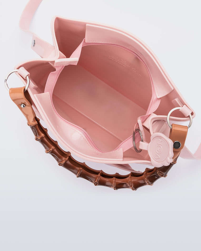 Inside view of the Melissa Tie handbag in pink shows a zipper closure for the main compartment.