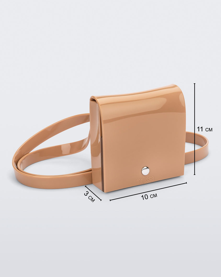 An angled front view of a beige Melissa Like It purse with a silver button and a Melissa logo on the front, showing the dimesions of the bag which reads 3 centermeters deep, 10 centermeters wide and 11 centermeters high.