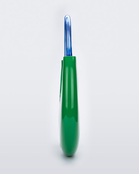 Side view of a Green/Blue Melissa Moon Bag with a crescent shaped green bag base and a blue beige top strap.