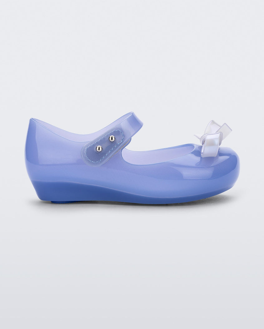Side view of a Blue Mini Melissa Ultragirl Bow flat with a blue base, top strap and white bow detail on the front.