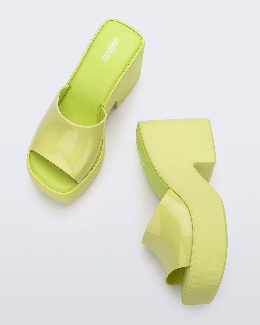 Top view and side view of a pair of Melissa Posh platform slides in Yellow