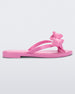 Side view of a Pink Melissa Slim flip flop with a bow detail on the front straps.