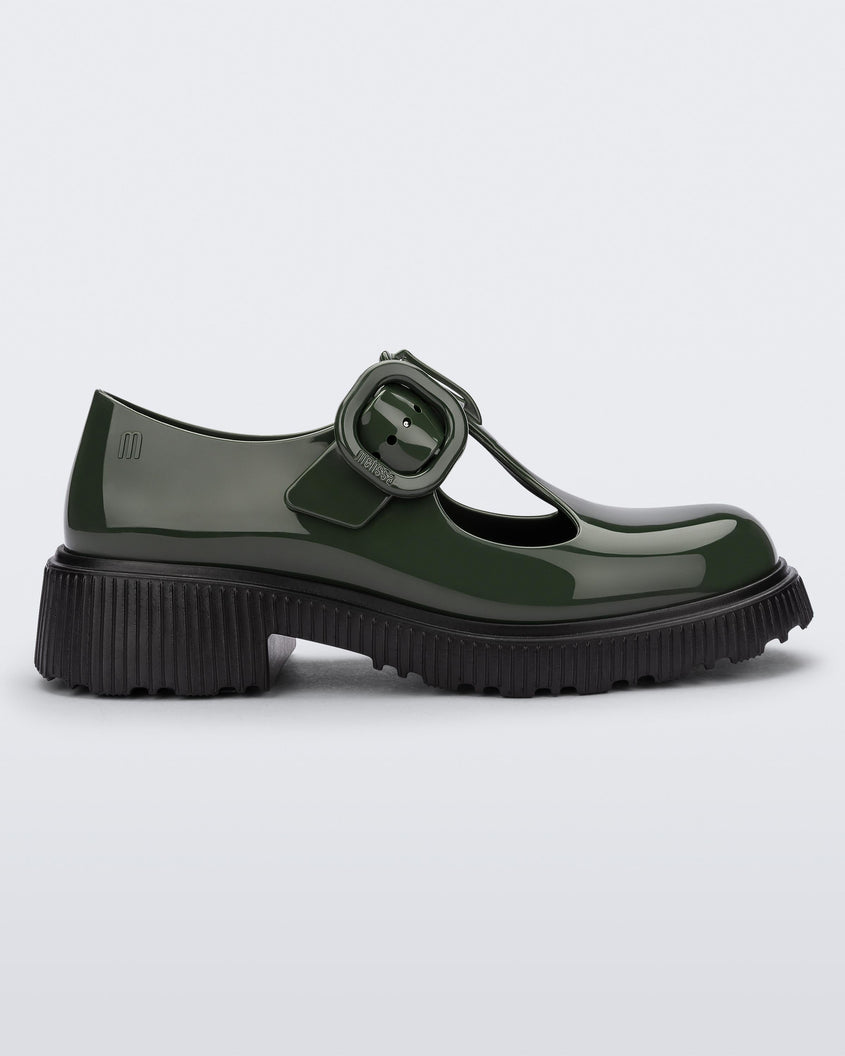 Side view of a Green Mini Melissa Jackie loafer with a green base, two cut outs, a green buckle detail strap and black sole.