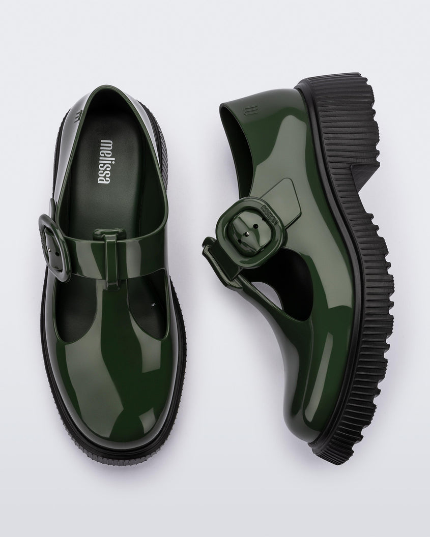 A top and side view of a pair of Green Mini Melissa Jackie loafers with a green base, two cut outs, a green buckle detail strap and black sole.