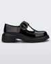 Side view of a black Melissa Jackie loafer with two cut outs and a buckle detail strap.