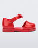 Side view of a red Mini Melissa Amy sandal with a red closed toe section and a back red glitter strap with a lace like bow detail.