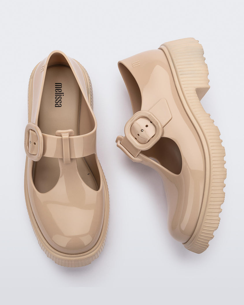 A top and side view of a pair of beige Melissa Jackie loafers with two cut outs and a buckle detail strap.
