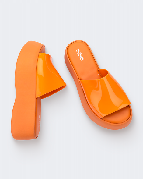 Top and side view of a pair of orange Melissa Becky platform slides. 