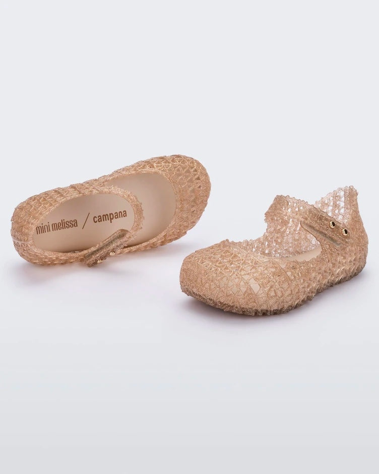 Top and angled view of a pair of Mini Melissa Campana beige glitter flats for baby with an open woven texture.