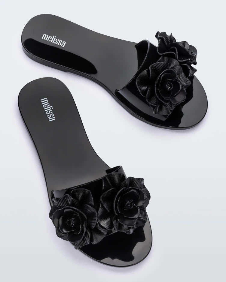 Top view of a pair of black Melissa Babe Garden slides with two flowers on the front strap.