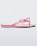 Side view of a Pink/Glitter Pink Mini Melissa Harmonic Sweet flip flop with a pink sole, pink glitter straps with a bow on top.