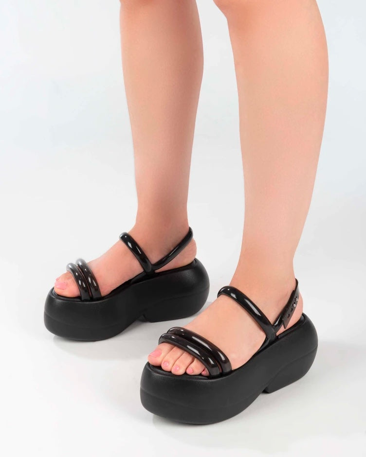 A model's legs wearing black Melissa Airbubble Platform sandals