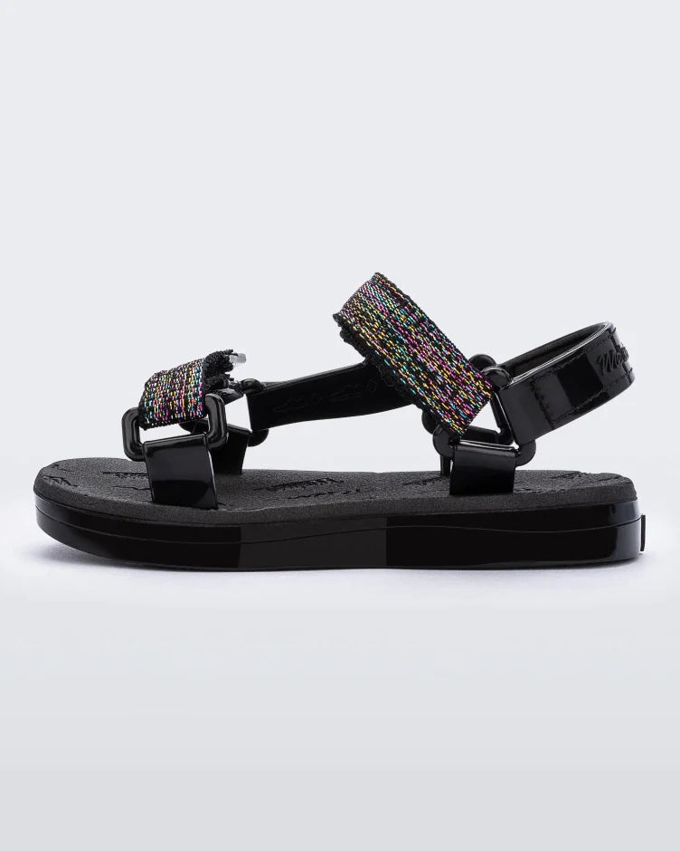 Side view of black Mini Melissa Papete sandals with glitter and black straps.