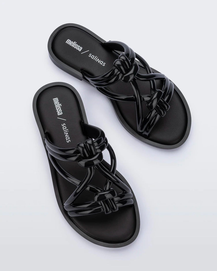 Top view of a pair of black Melissa Wave Slides with several front straps with knot like details.