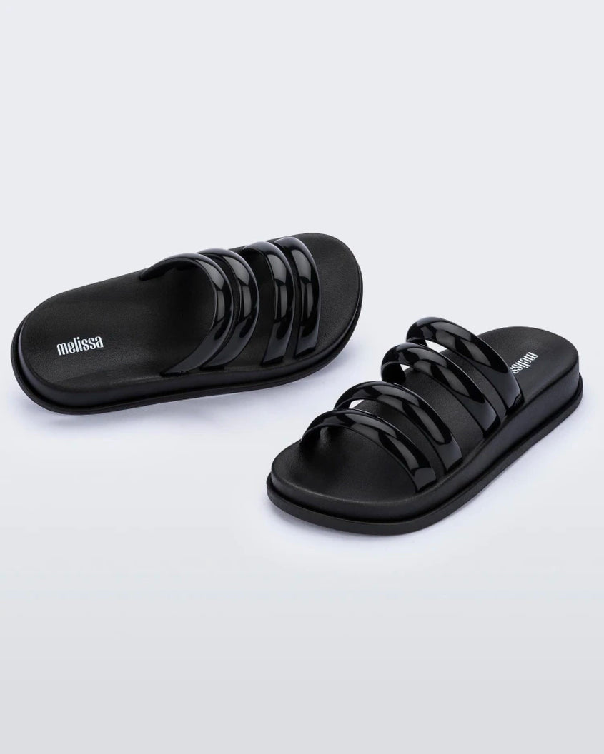 An angled front and top view of a pair of Black Melissa Soft Wave Slides with 4 front straps.