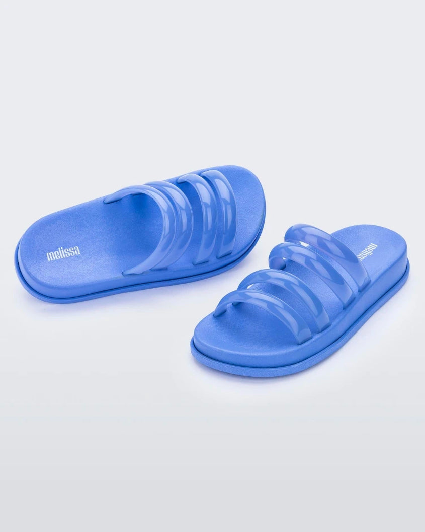 An angled front and top view of a pair of Blue Melissa Soft Wave Slides with 4 front straps.