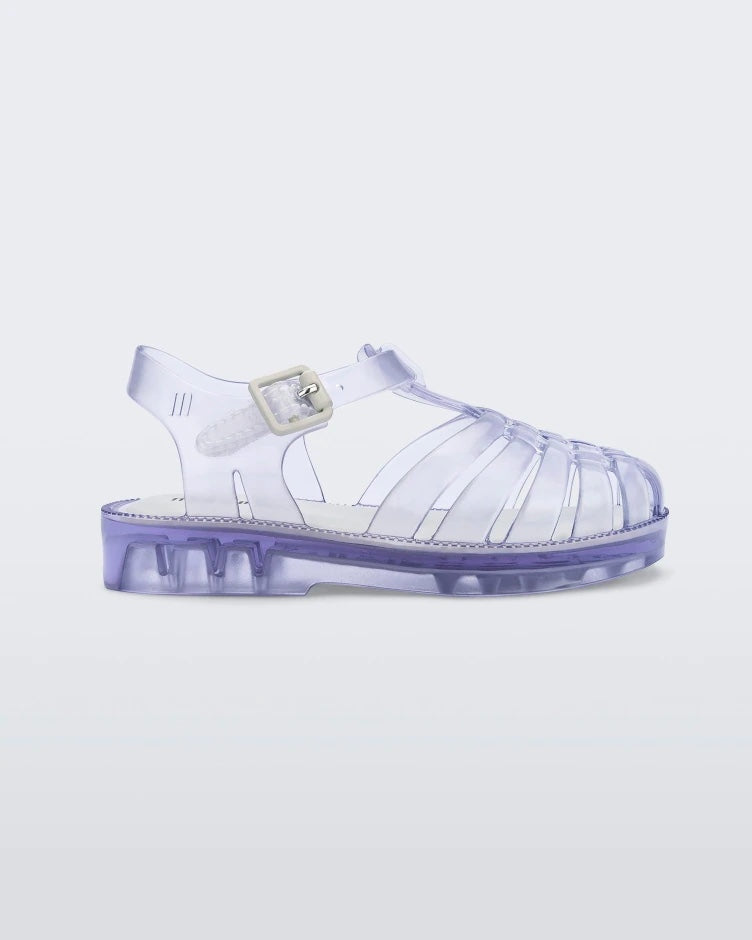 Side view of a clear Mini Melissa Possession sandal with several straps and a closed toe front.