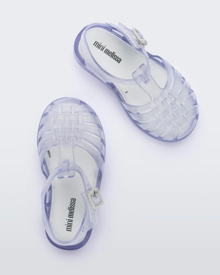 Top view of a pair of clear Mini Melissa Possession sandals with several straps and a closed toe front.