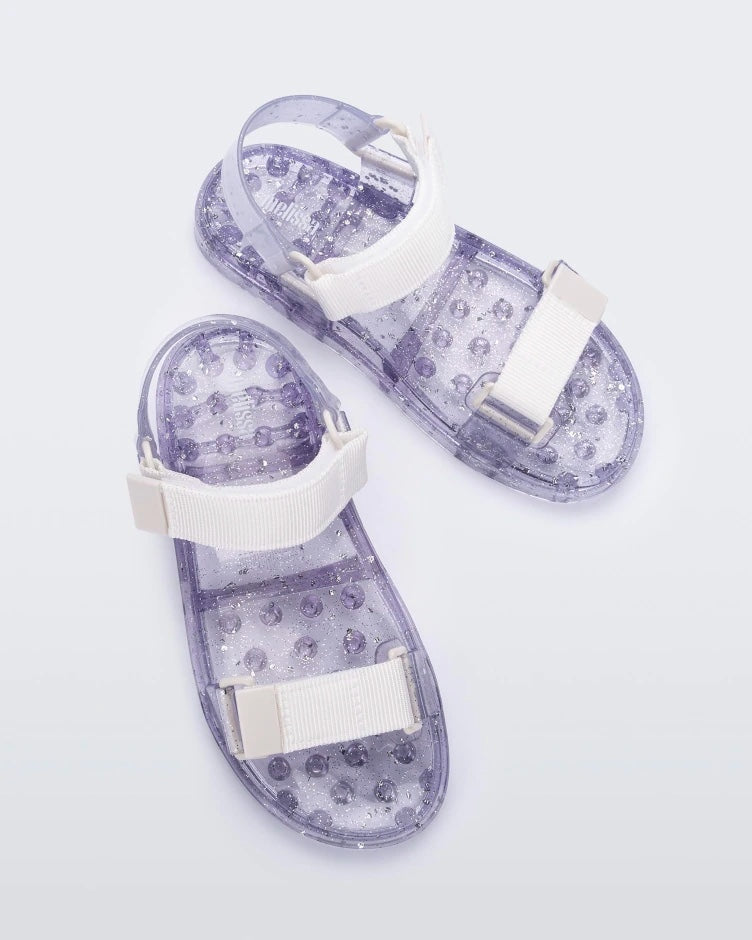 Top view of a pair of Melissa Wide Papete sandals with transparent silver glitter sole with white/clear velcro straps 