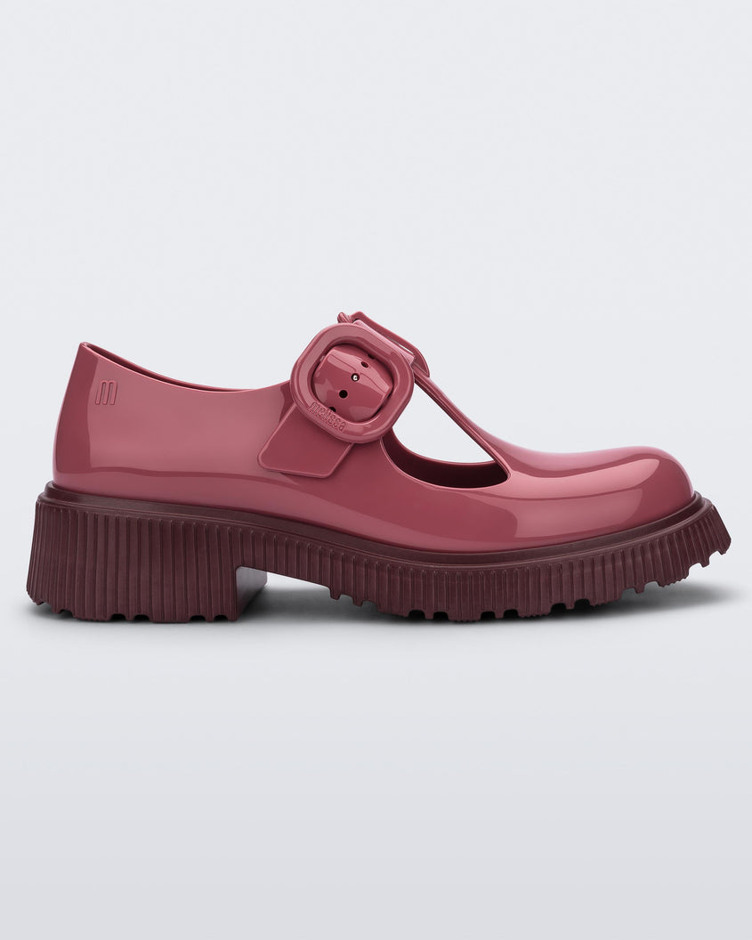 Side view of a Burgundy Mini Melissa Jackie loafer with a Burgundy base, two cut outs, a Burgundy buckle detail strap and brown sole.