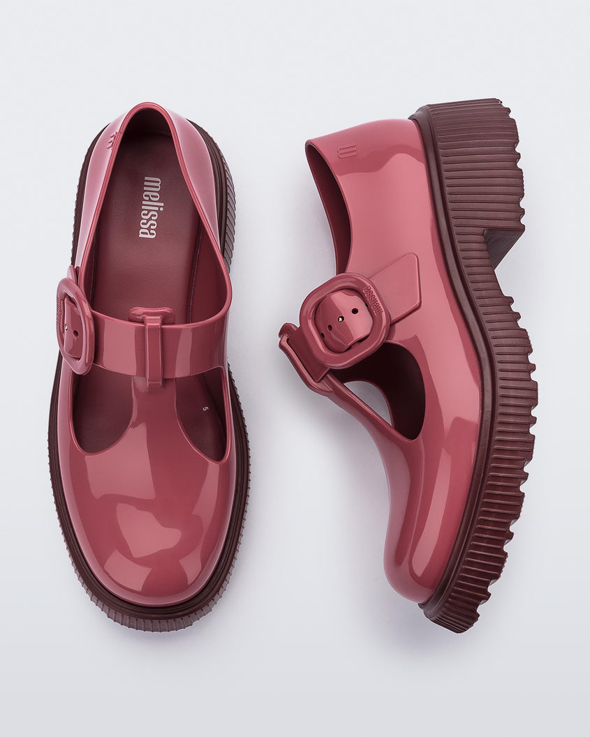 Top and side view of a pair of Burgundy Mini Melissa Jackie loafers with a Burgundy base, two cut outs, a Burgundy buckle detail strap and brown sole.