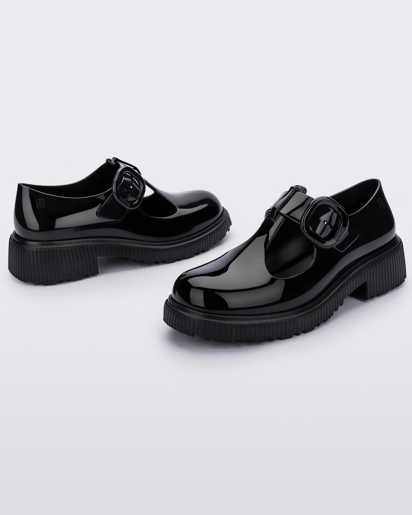 Side view of a pair of black Melissa Jackie loafers with two cut outs and a buckle detail strap.