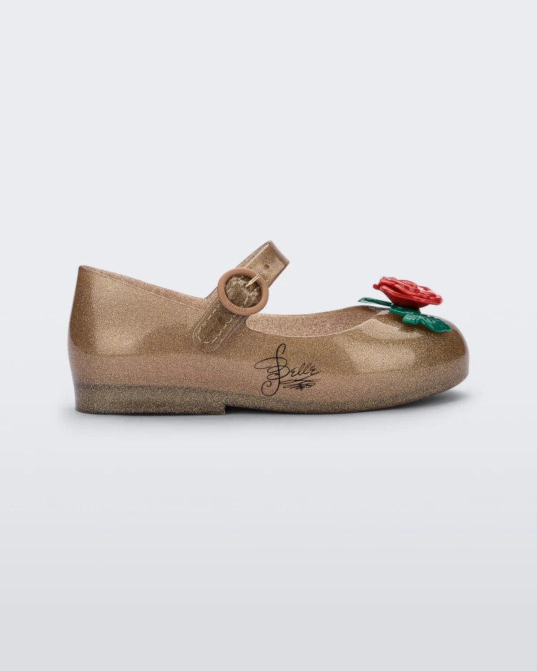 Side view of a gold/red Mini Melissa Sweet Love Princess flat with a gold base with Belle in script on the side, a top strap, a rose detail on the toe and a drawing of Belle of Beauty and the Beast on the insole.