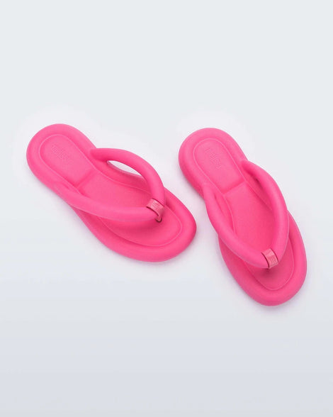 Top view of a pair of pink Melissa Free Flip Flops with puffer-like straps.